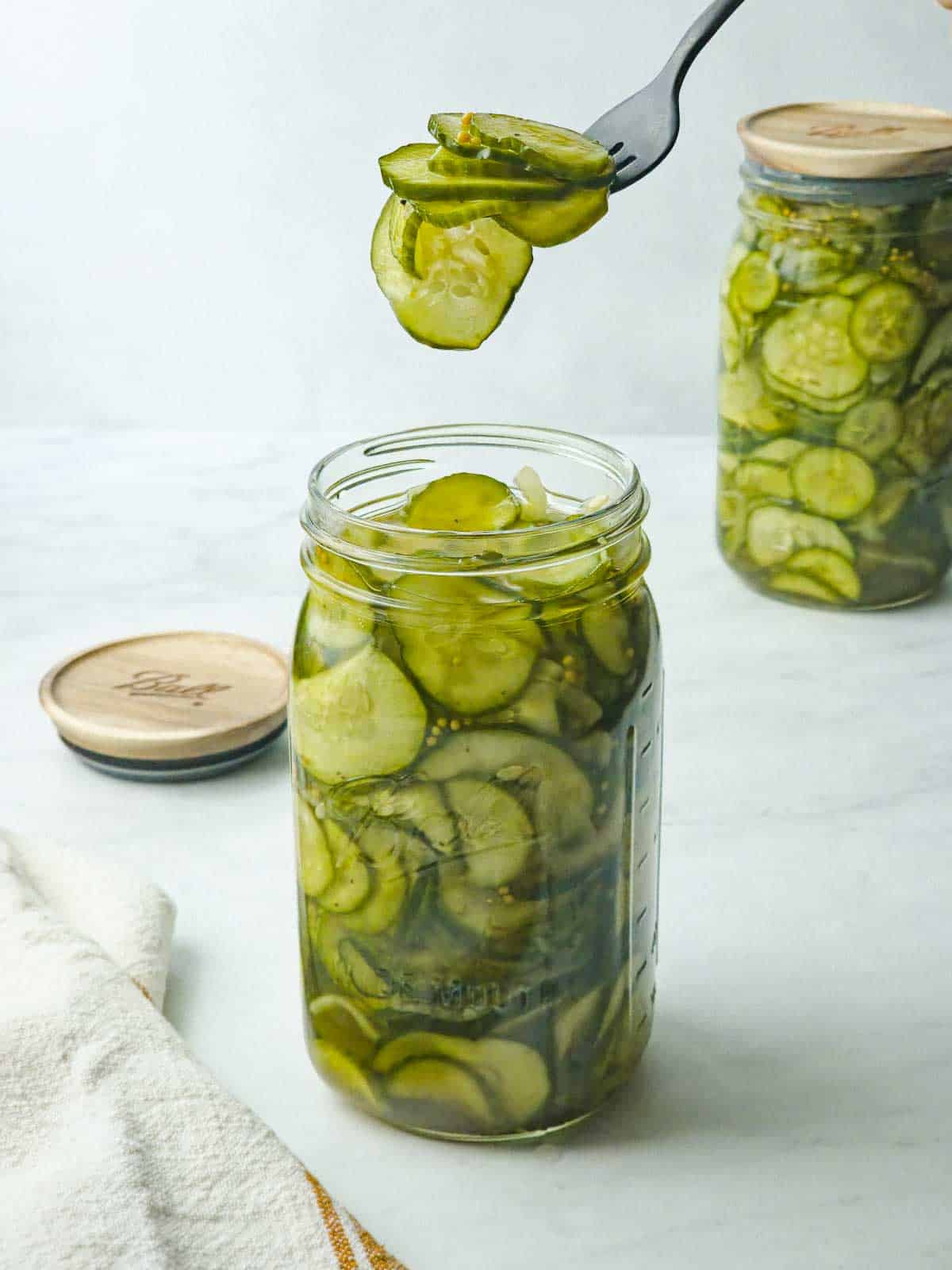 A black fork serving a portion of quick bread and butter pickles.