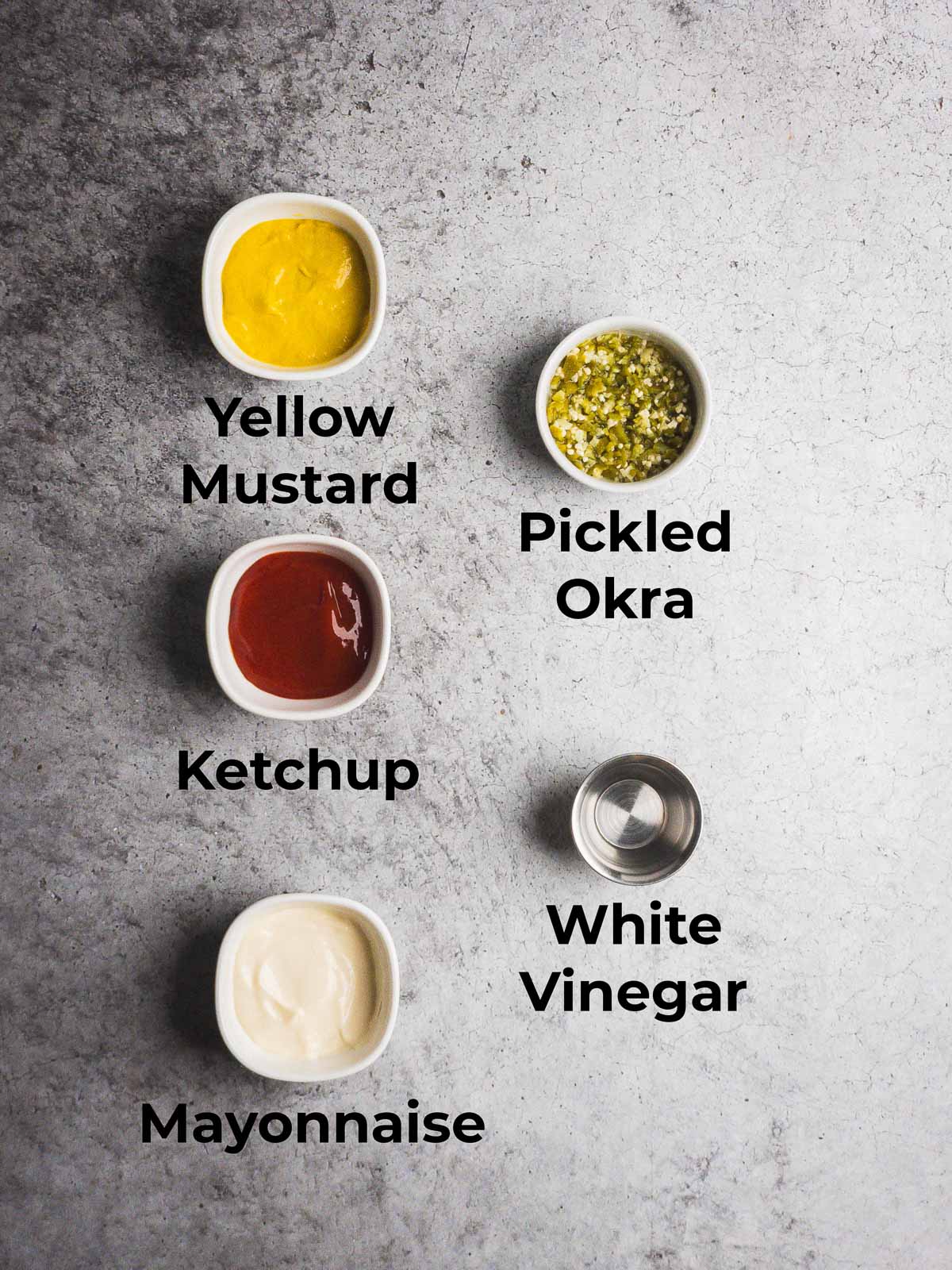 Ingredients for pickled okra burger sauce on a stone counter.