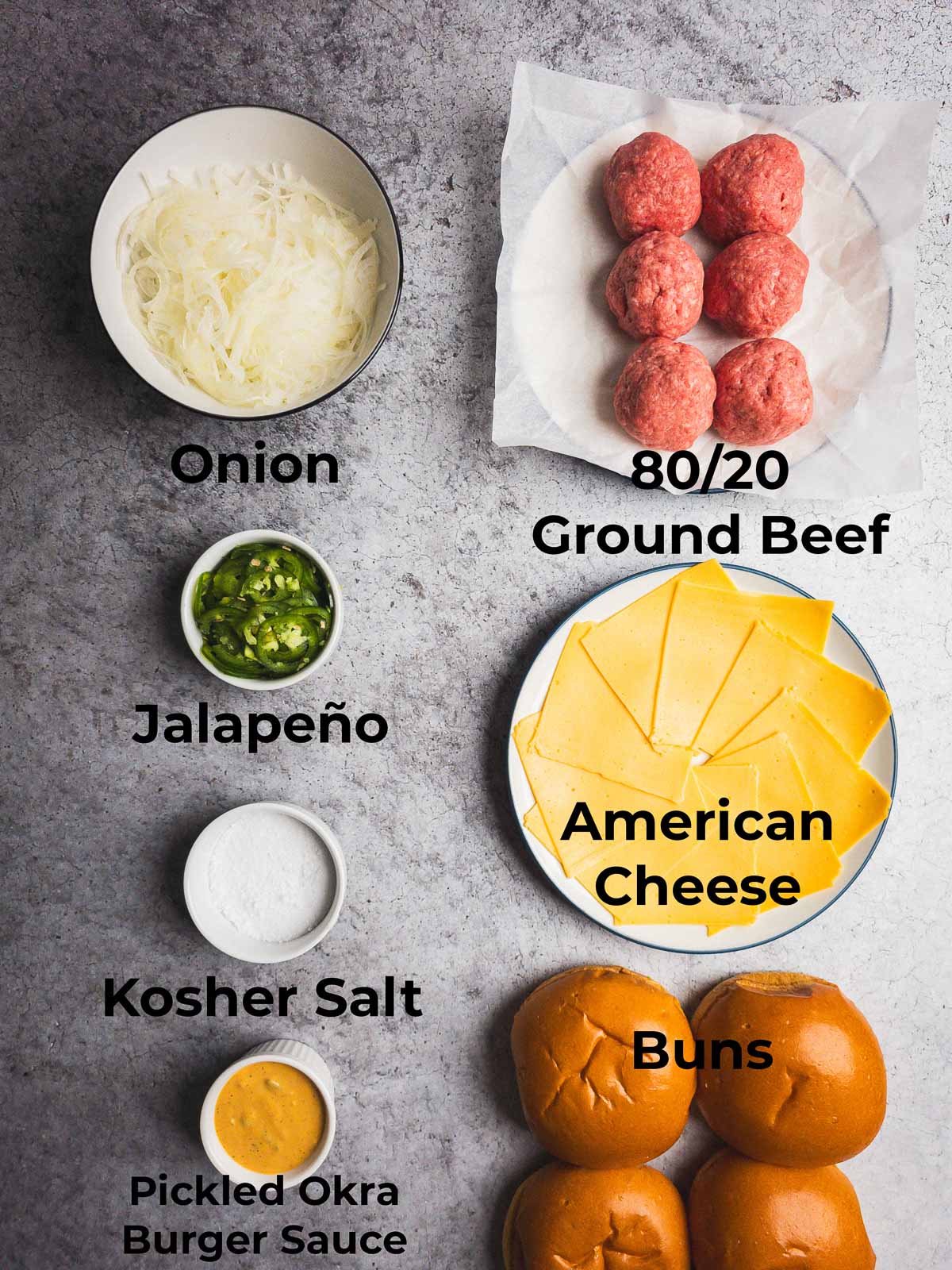 Ingredients for smash burgers with onion and jalapeno on a stone counter.