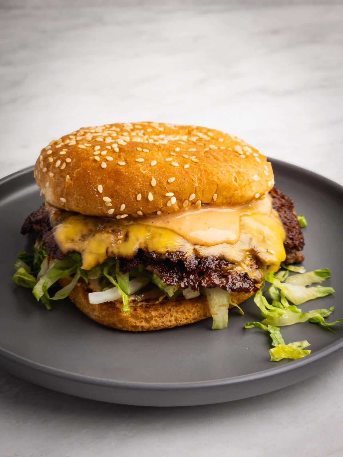Classic double smash burger with crispy edges, melty cheese, and homemade burger sauce on a plate.