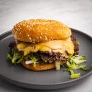 Classic double smash burger with crispy edges, melty cheese, and homemade burger sauce on a plate.
